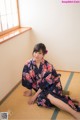 A woman in a kimono sitting on a tatami mat.