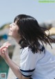 A woman in a white shirt and blue and white striped shirt.