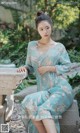 a woman in a blue dress sitting on a stone bench