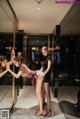 A group of young women standing in front of a mirror.